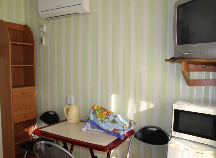 Шкаф, зона для приема пищи, телевизор в номере Комфорт отель Прибой Саки