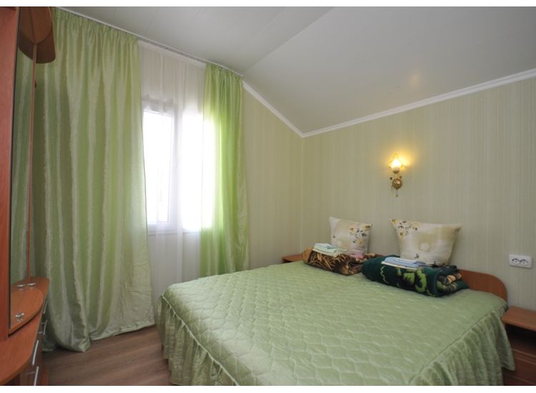 Двуспальная кровать в номере «Ривьера» отель Прибой Саки