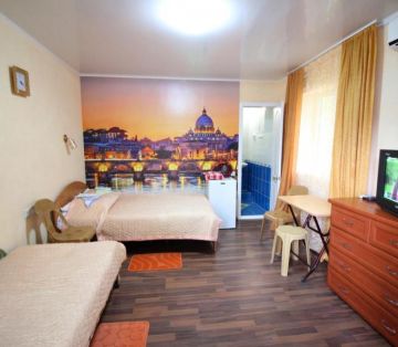 Двуспальная кровать, фотообои вечерний город, тв, комод в номере Стандарт 3х местный отель Прибой Саки