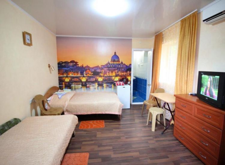Двуспальная кровать, фотообои вечерний город, тв, комод в номере Стандарт 3х местный отель Прибой Саки