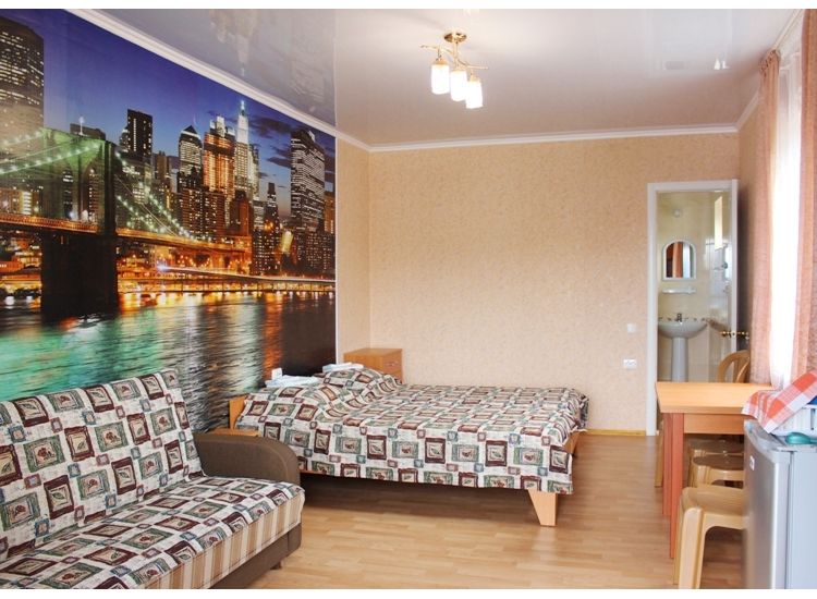 Кровать и раскладной диван, фотообои мост ночного города в номере Стандарт 4х местный отель Прибой Саки