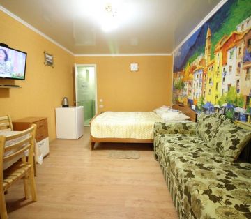 Кровать, раскладной диван у стены со сказочным городом в номере Стандарт 4х местный отель Прибой Саки