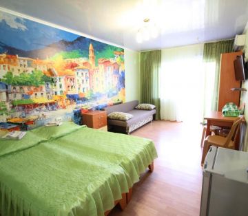 Кровати с зеленым покрывалом и диван с декоративными подушками в номере Стандарт 4х местный отель Прибой Саки