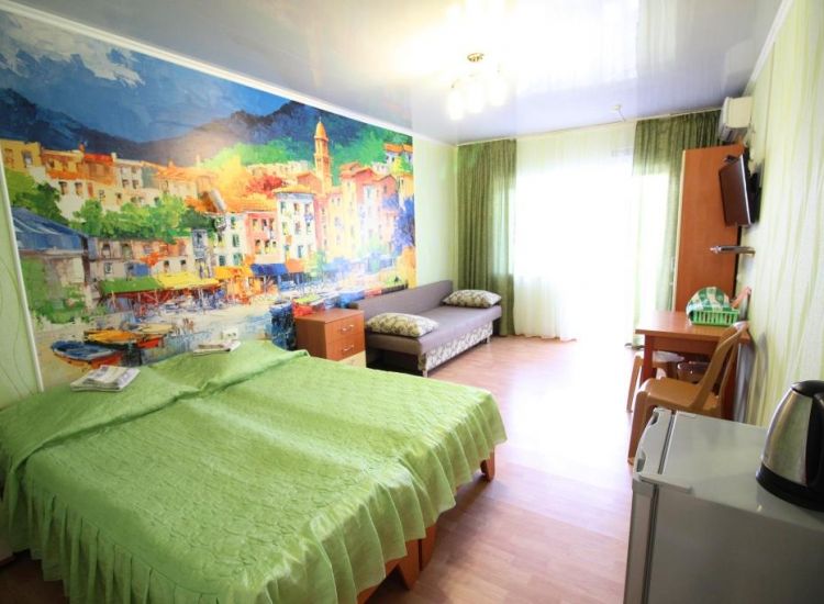 Кровати с зеленым покрывалом и диван с декоративными подушками в номере Стандарт 4х местный отель Прибой Саки