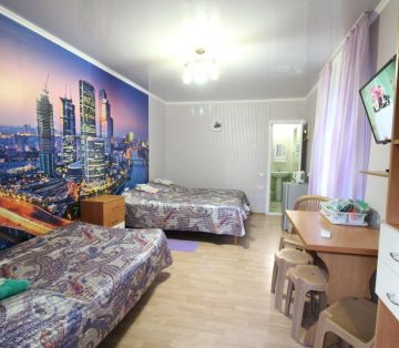 4 спальных места, стена с ночным городом в номере Стандарт 4х местный отель Прибой Саки
