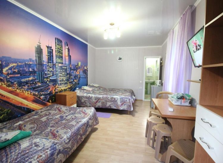 4 спальных места, стена с ночным городом в номере Стандарт 4х местный отель Прибой Саки
