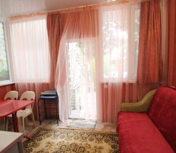 Красный и диван и стол со стульями в номере «Арабский» отель Прибой Саки